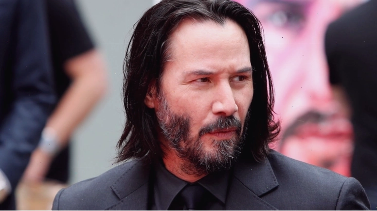 Keanu Reeves nhìn sang một bên với vẻ mặt trầm ngâm