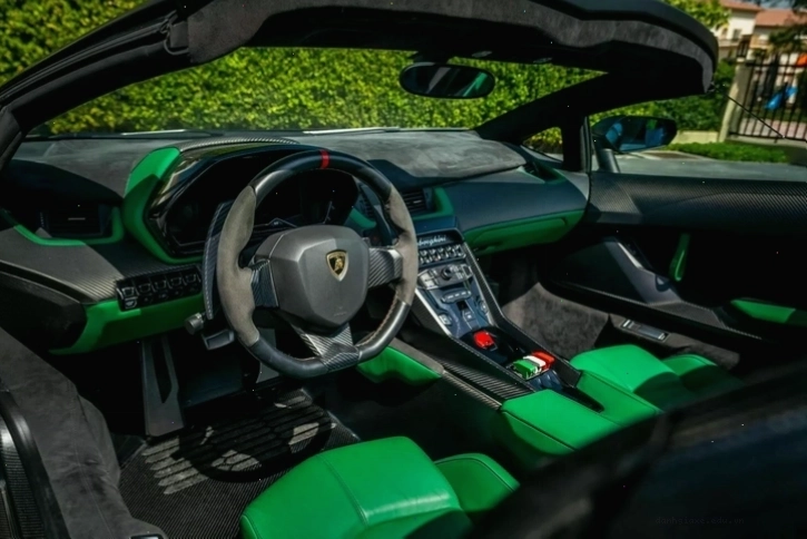 Nội thất carbon fiber của Lamborghini Veneno Roadster với tông đen chủ đạo và các chi tiết xanh lá hài hòa.